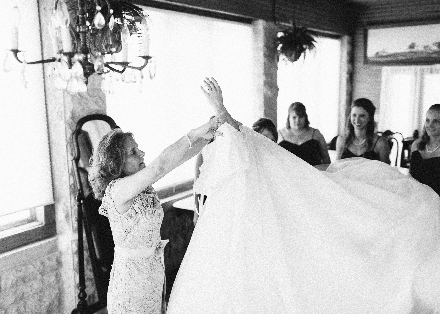 bride putting on wedding dress