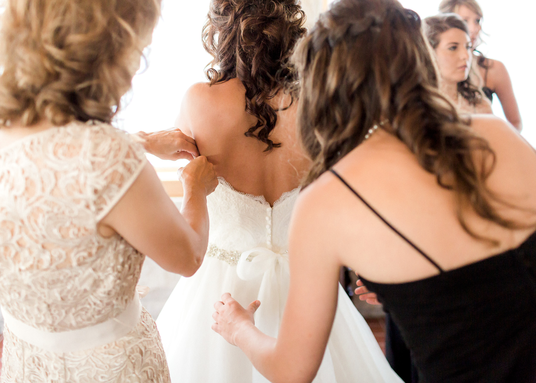 tying bow on wedding dress