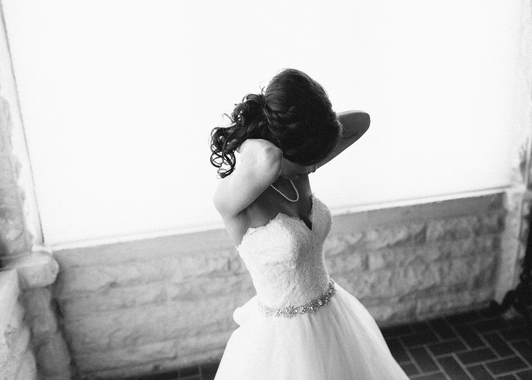 bride putting on necklace