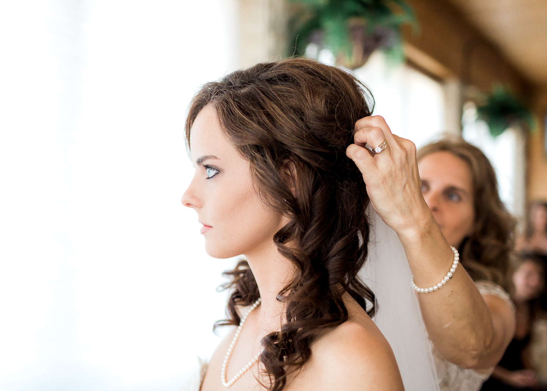 mother putting veil on bride