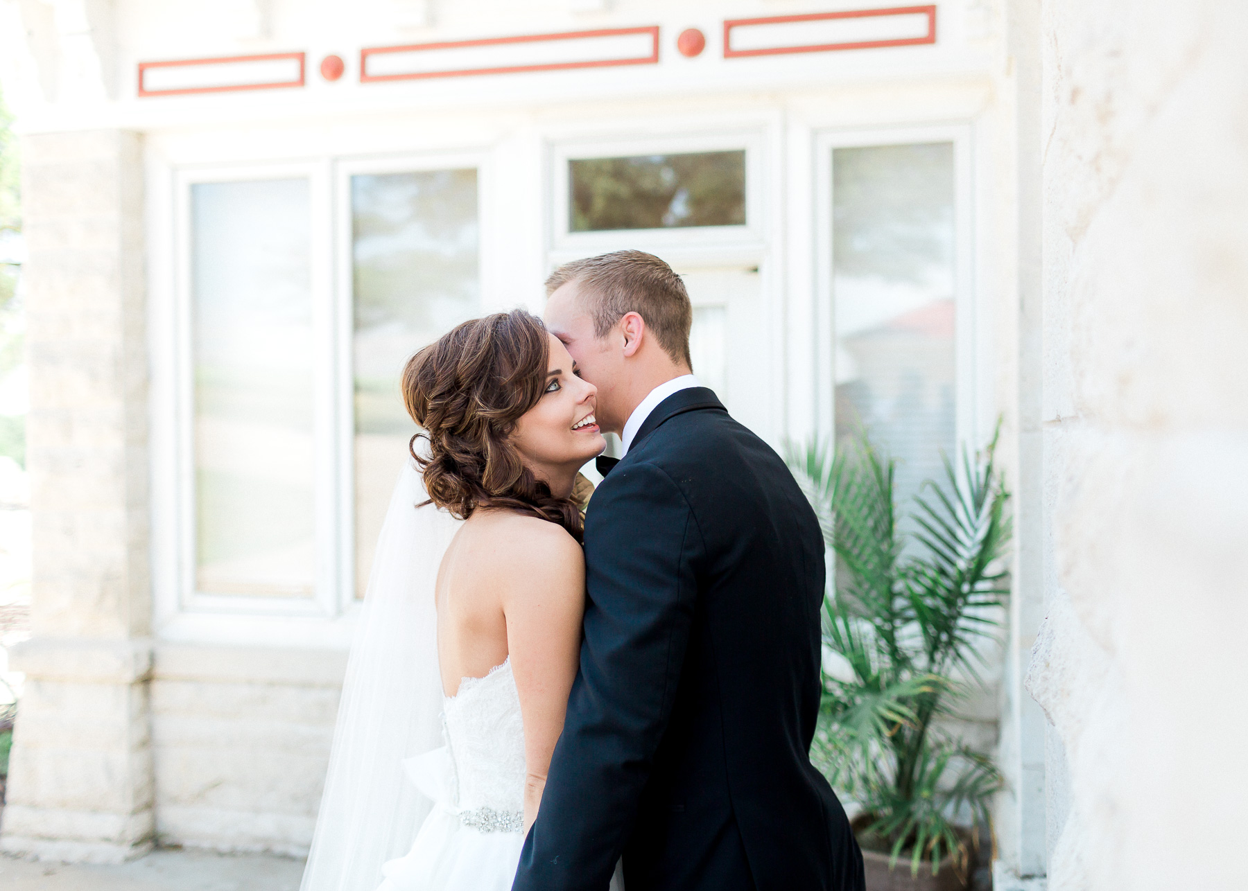 groom whispering in bride's ear