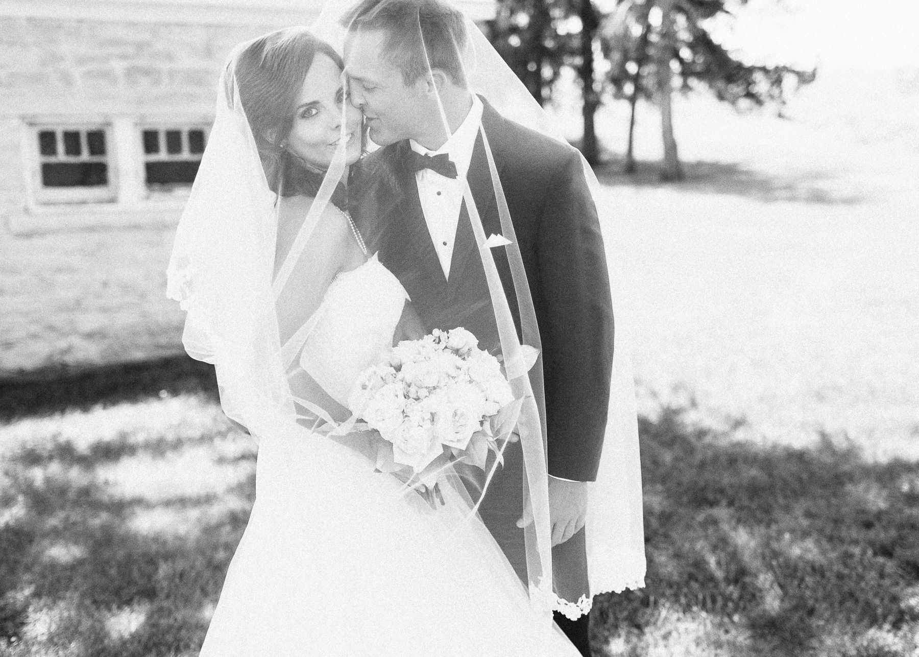 bride and groom underneath veil