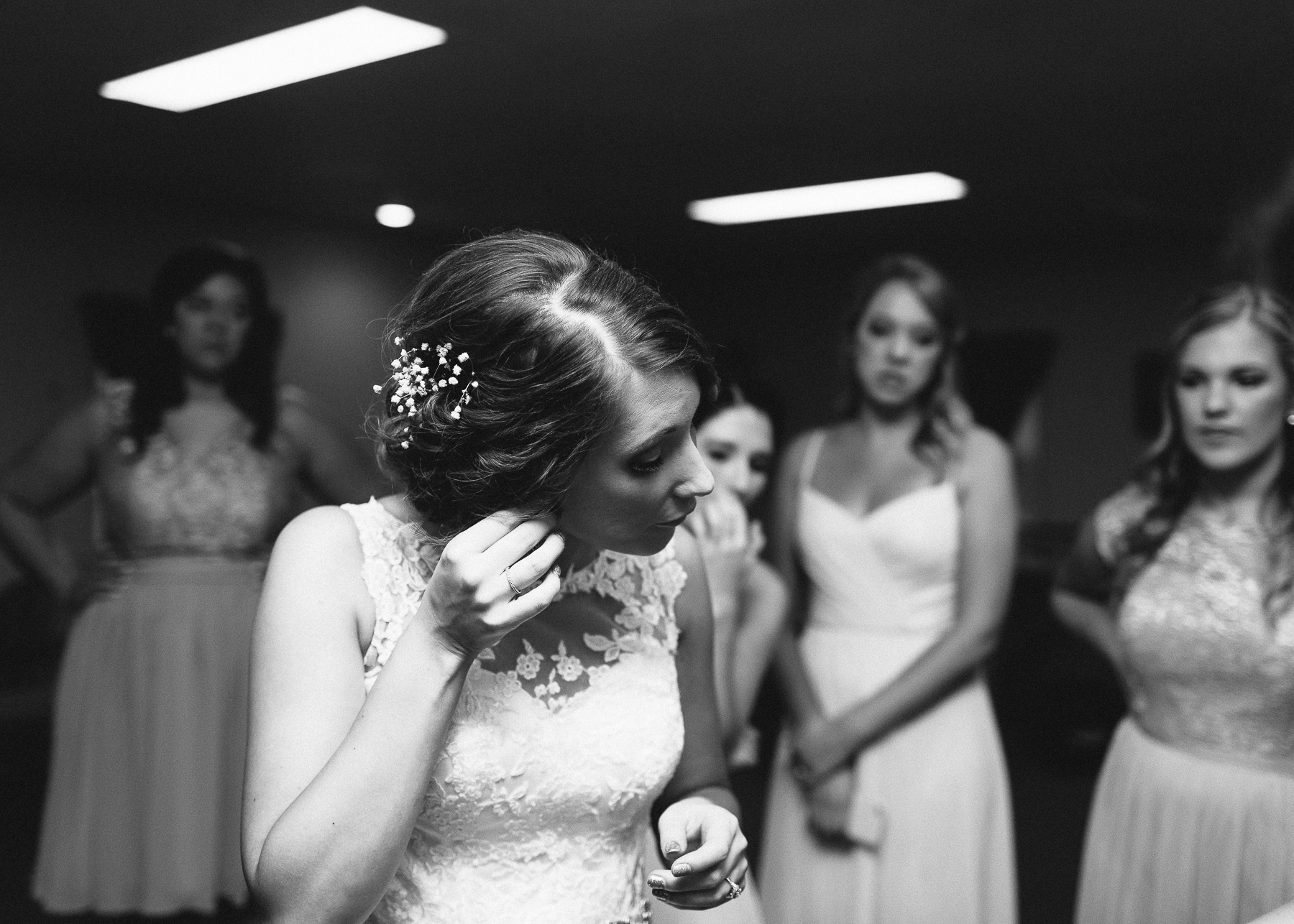 mother and sister helping button her wedding dress