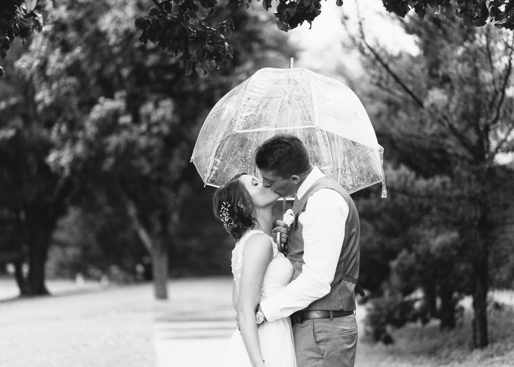 Zach and Abby kissing under umbrella