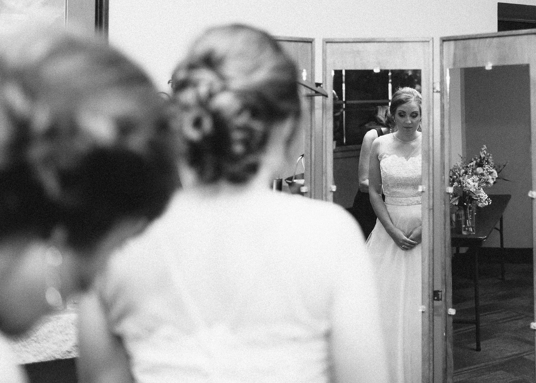 bride looking at wedding dress in the mirror