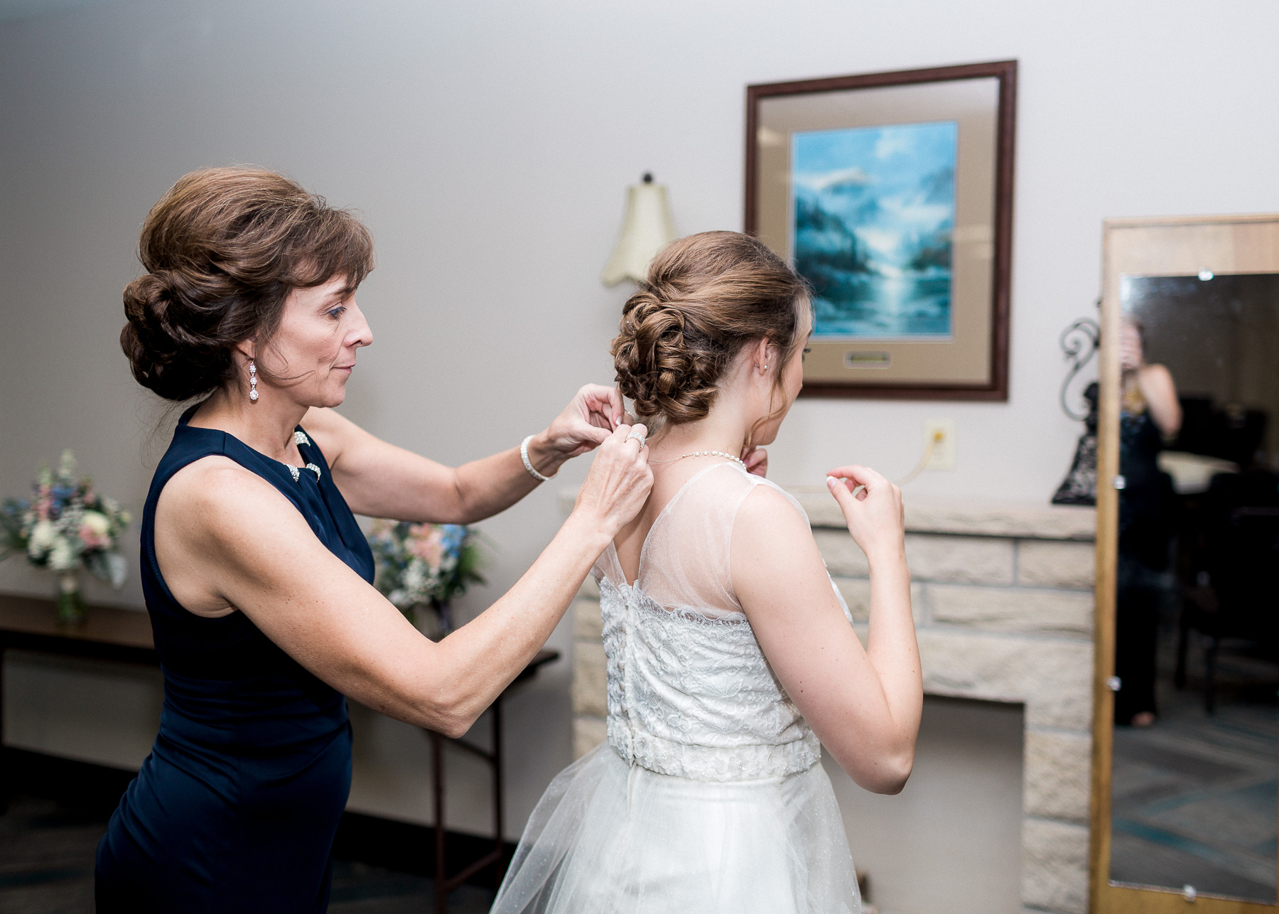 bride putting on necklace