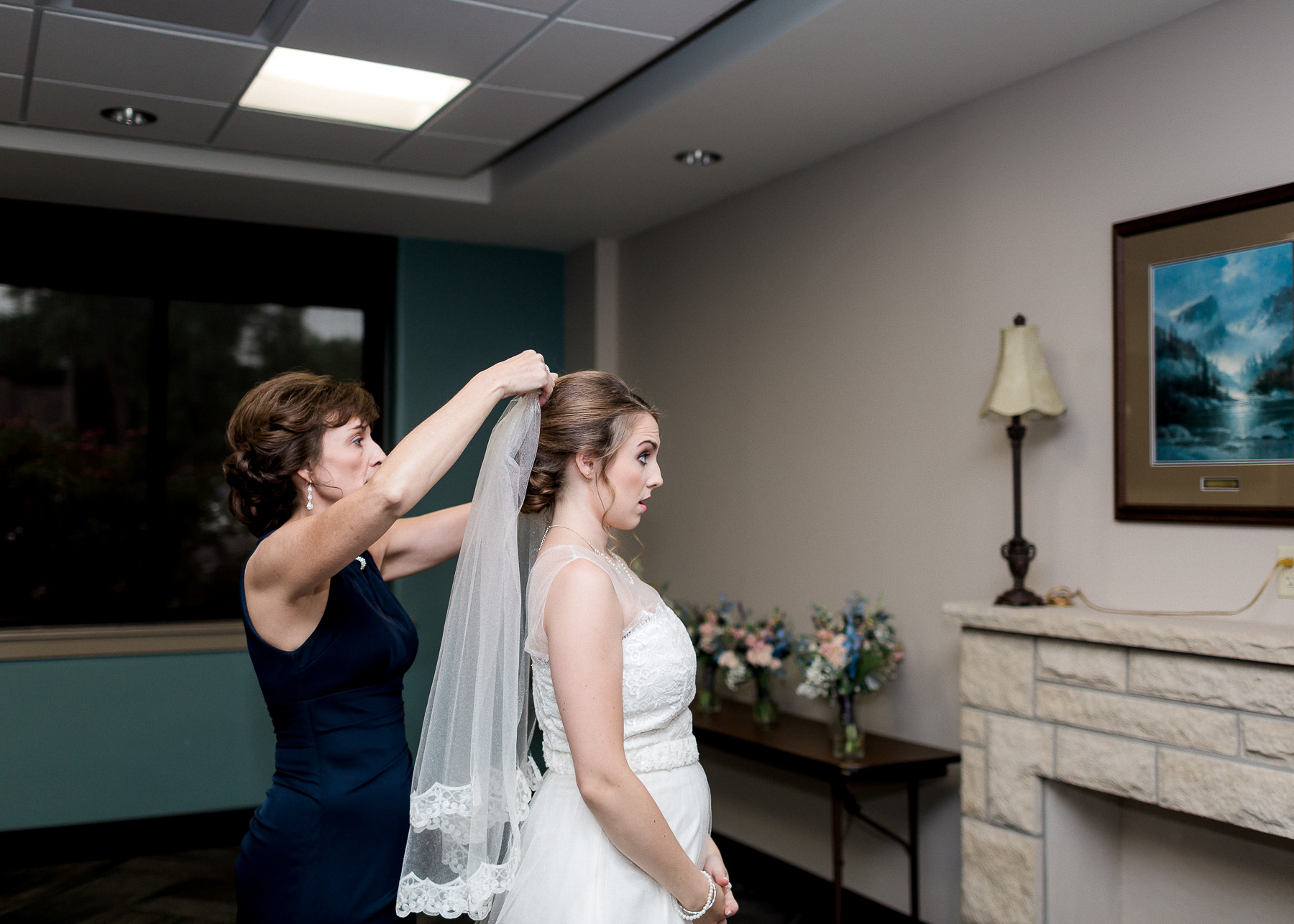 mother putting veil on bride