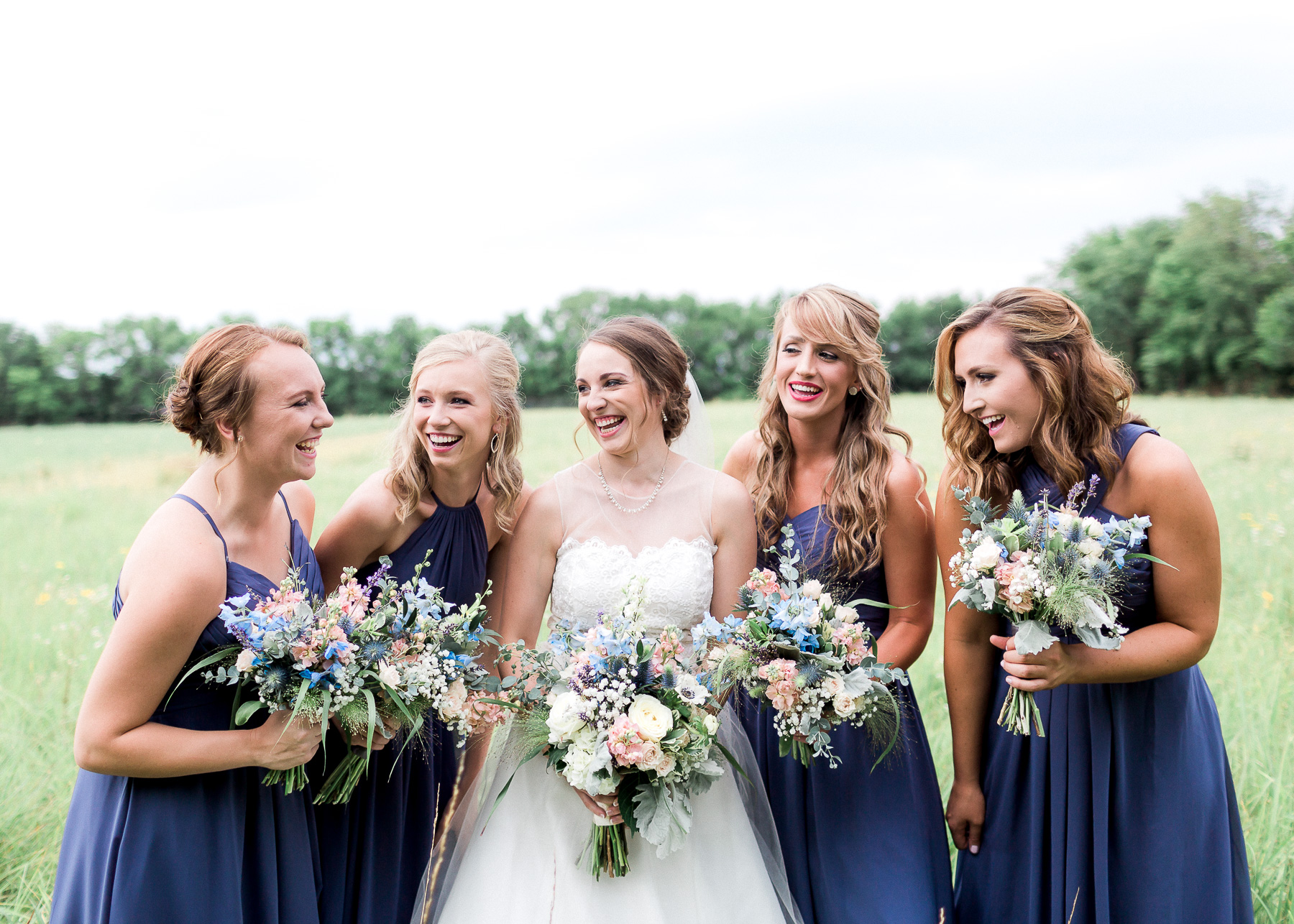 bridesmaids with bride laughing