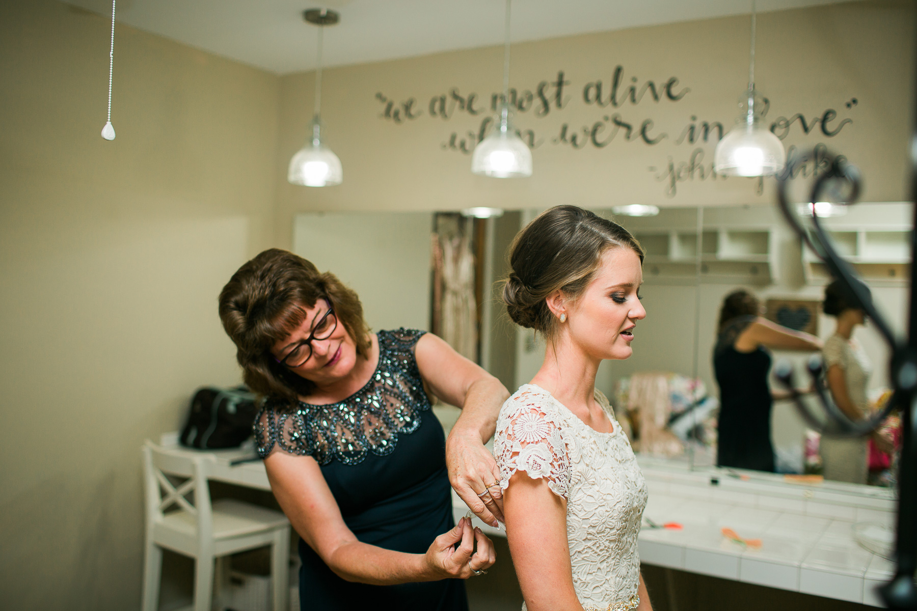 Mom pinning bride's dress