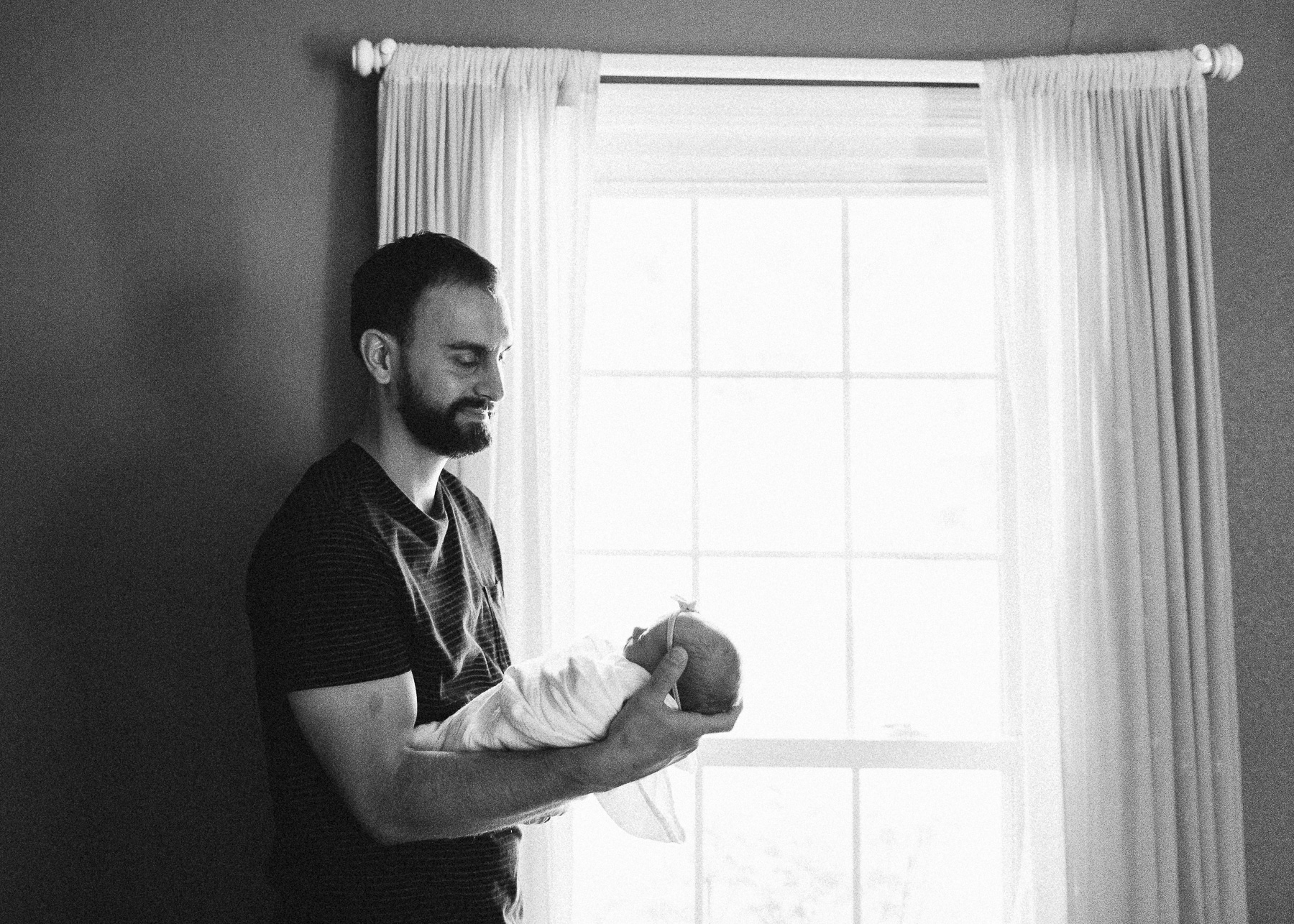 daddy holding baby near window