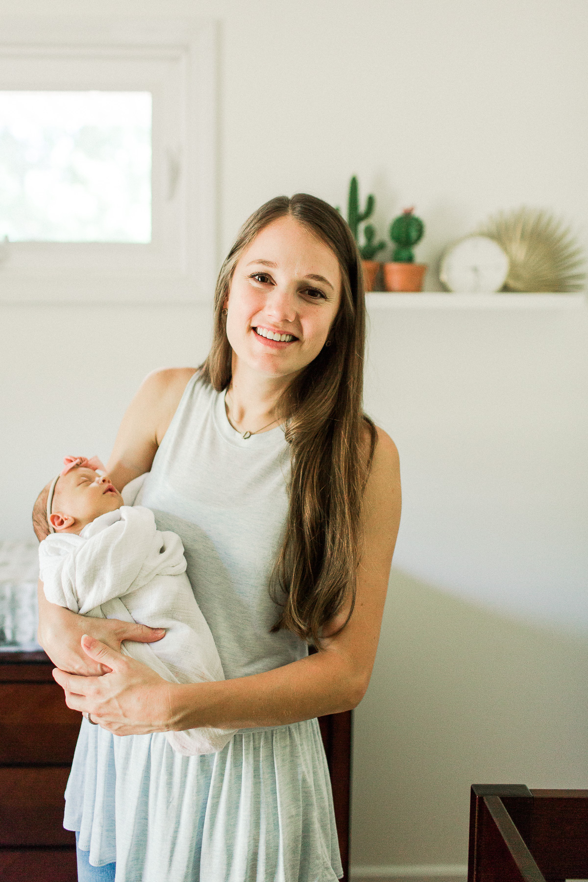 mama smiling at camera while holding baby girl