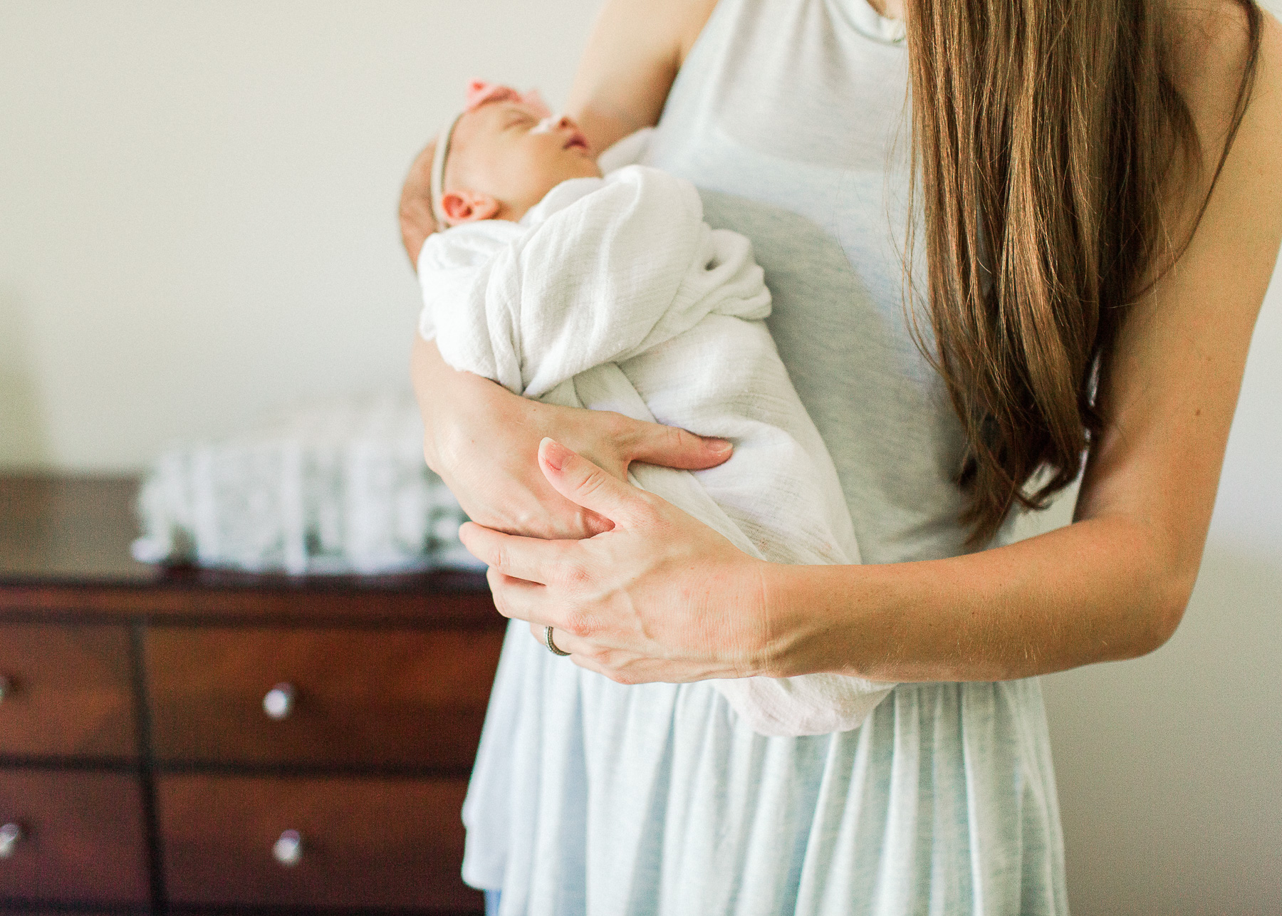 close up of mama's hands cradling baby girl